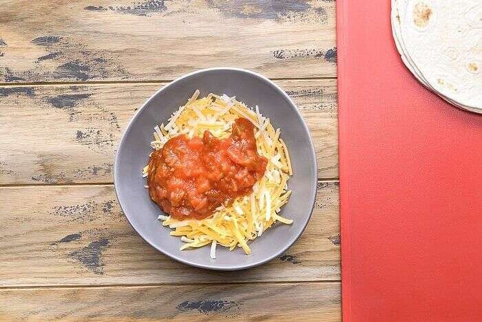 Shredded Mexican cheese and salsa prepared for air-fryer quesadillas