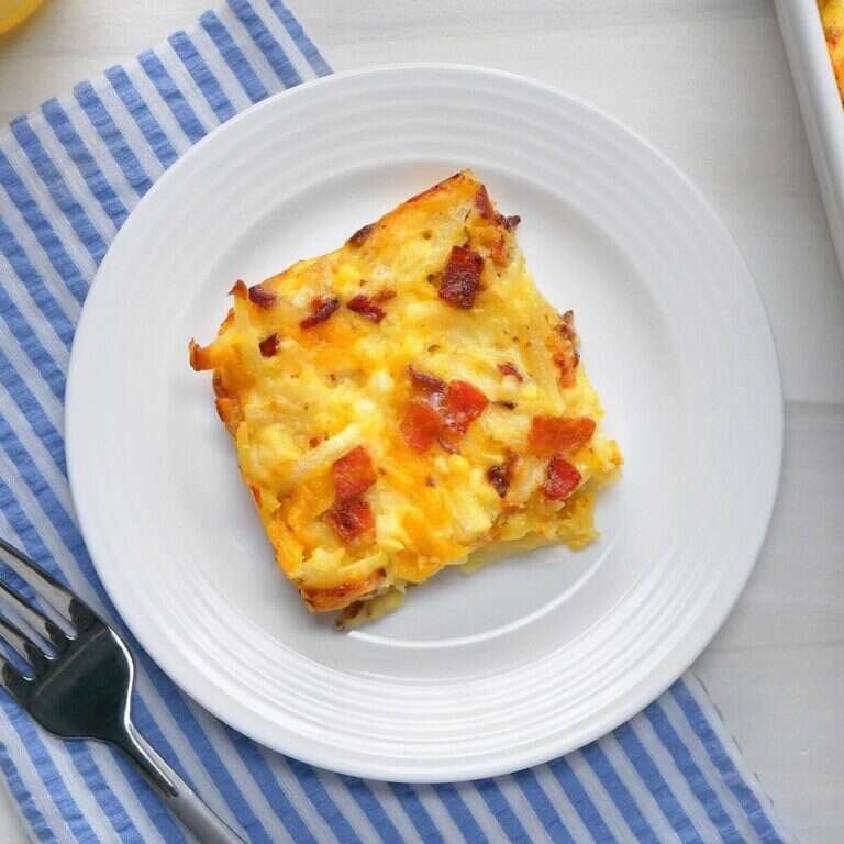 Amish breakfast casserole with bacon, hash browns, eggs, and melted cheese