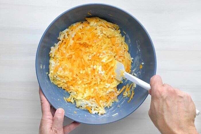Eggs, cheeses, hash browns, bacon, and onion combined for breakfast casserole