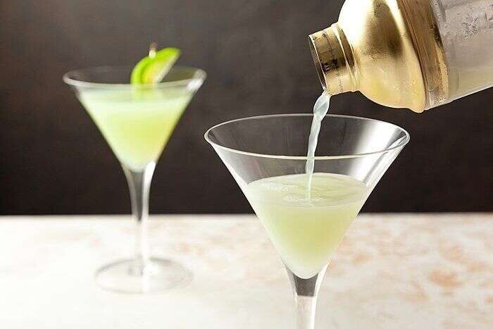 Apple martini being poured into a chilled cocktail glass