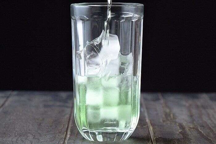 Vodka and sour apple liqueur added to an apple martini shaker