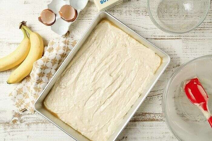 Banana bar batter spread in a jelly-roll baking pan