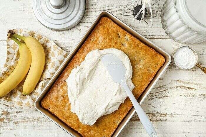 Cream cheese frosting spread over banana bars