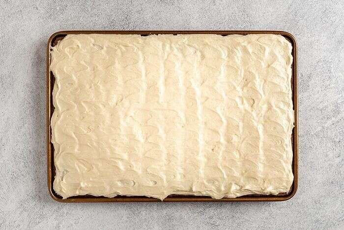 Cream cheese frosting spread over cooled banana bars