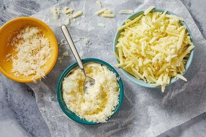 Mayonnaise butter coating and shredded cheeses prepared for grilled cheese