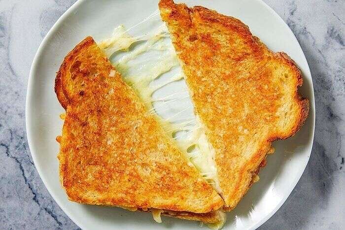 Golden grilled cheese sandwich showing gooey melted cheese between toasted bread