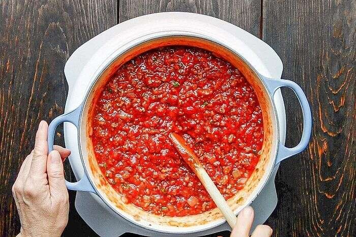Rich tomato meat sauce simmering for homemade lasagna