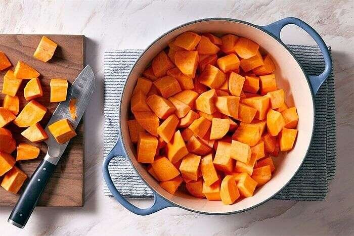Peeled sweet potatoes arranged in a pot for boiling