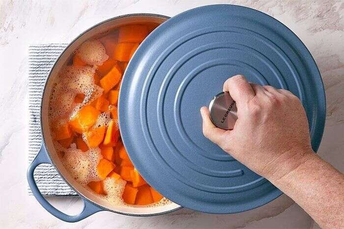 Sweet potatoes covered while simmering in a pot