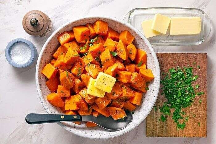 Boiled sweet potatoes with butter parsley and pepper