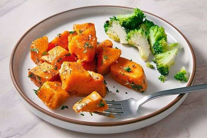 Boiled sweet potatoes garnished with parsley butter and pepper