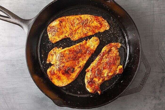 Seasoned chicken seared in a skillet for Cheddar Bay Biscuit Chicken Potpie