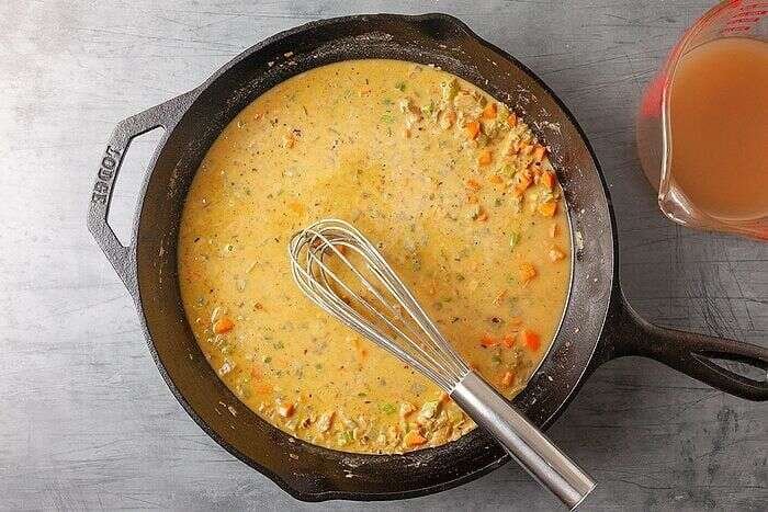 Creamy chicken potpie sauce whisked in a cast iron skillet