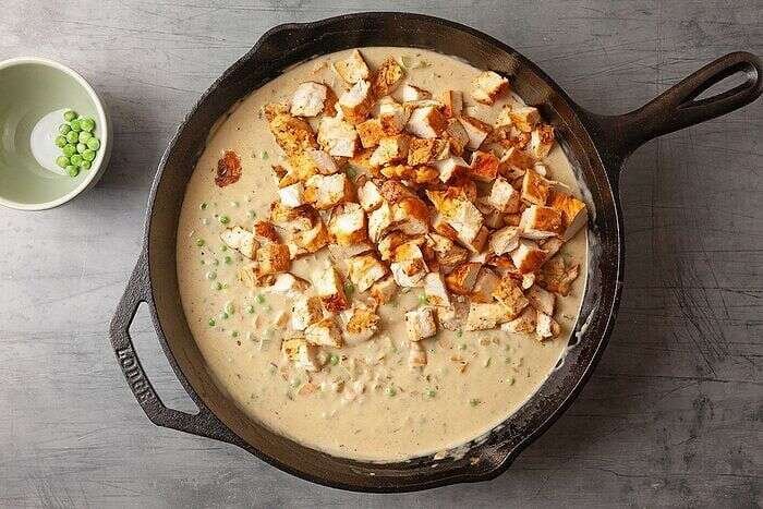 Cooked chicken folded into creamy potpie filling with herbs and peas