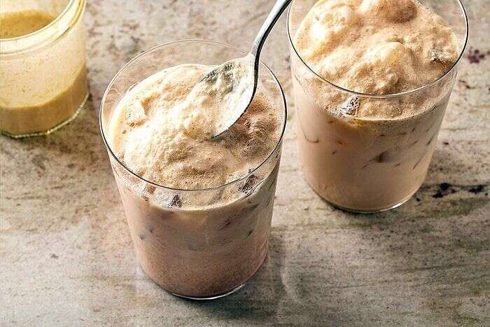 Iced chai latte with pumpkin cold foam being prepared