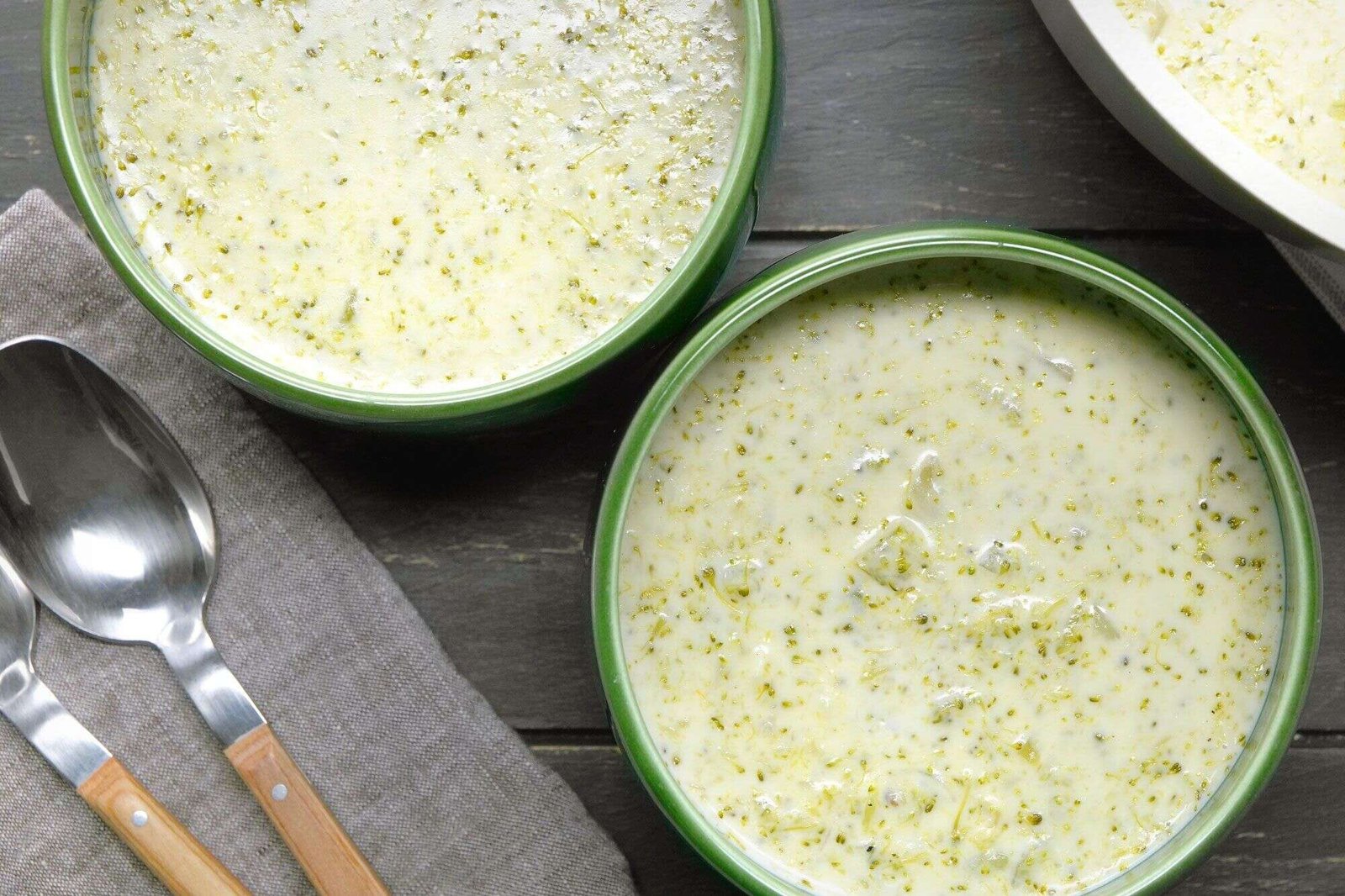 Creamy broccoli soup served warm in green bowls