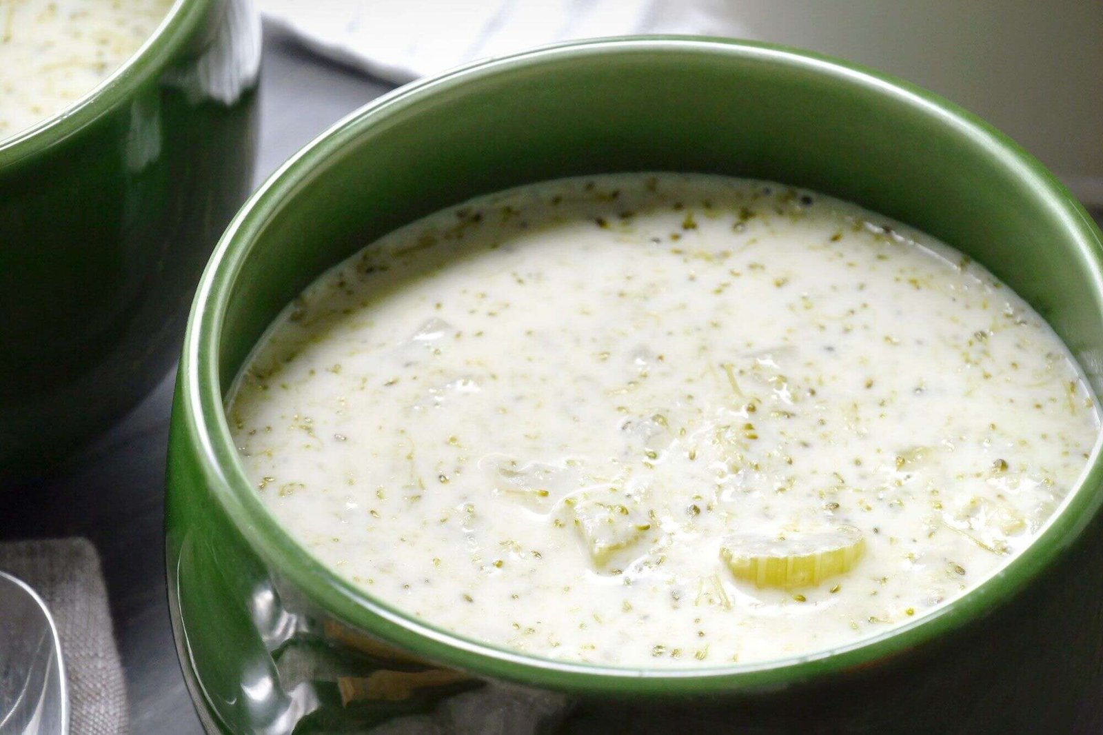 Creamy broccoli soup with tender broccoli pieces in green bowls