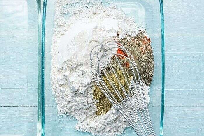 Mixing seasoned dry ingredients for crispy fried chicken