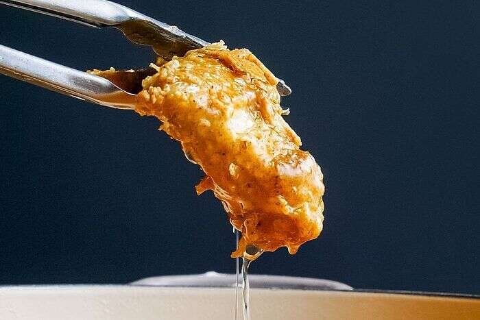 Golden crispy fried chicken lifted from hot oil
