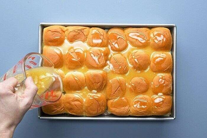 Buttery Dijon mustard topping drizzled over Cuban sliders