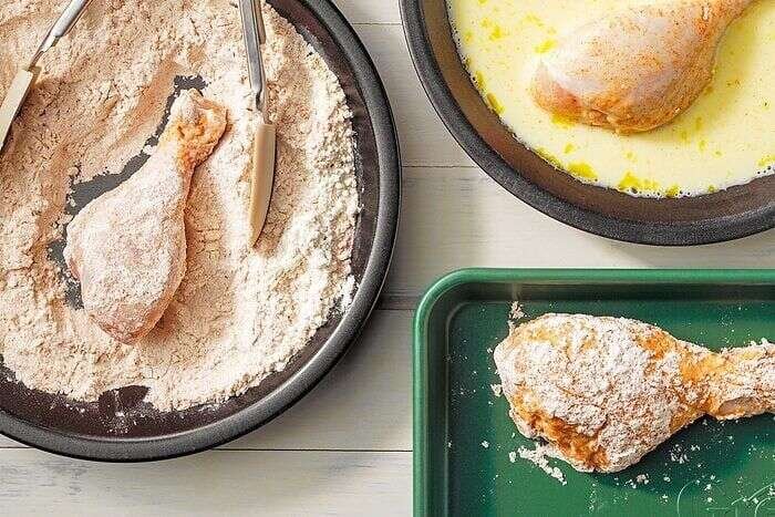 Chicken drumsticks coated in seasoned flour and egg mixture