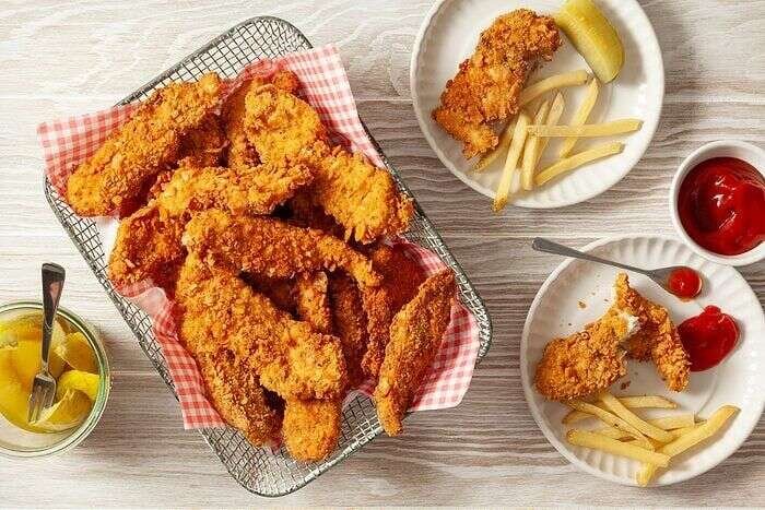 Crispy fried chicken strips served with fries and dipping sauce