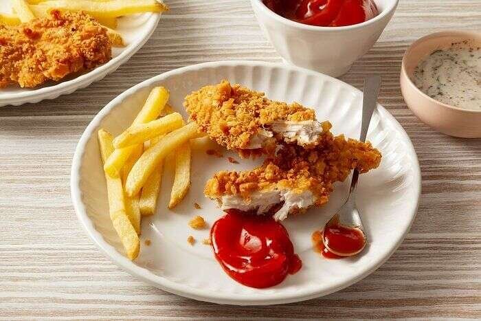 Golden crispy chicken strips served with fries and ketchup