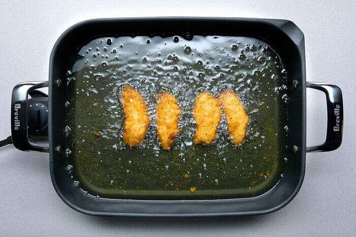 Chicken strips frying until golden and crispy in hot oil