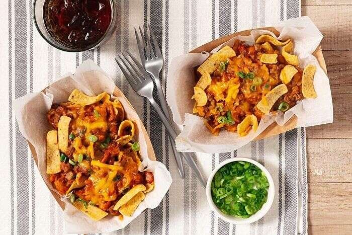 Baked Frito pie topped with green onions and ready to serve