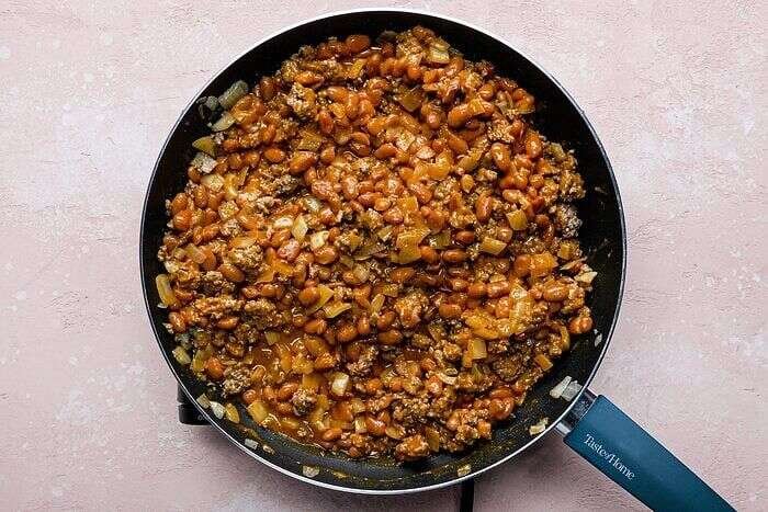 Ranch-style beans stirred into browned beef for Frito pie