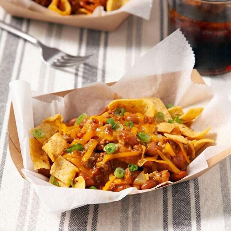 Frito pie casserole with crunchy Fritos, seasoned beef, beans, enchilada sauce, and melted cheese