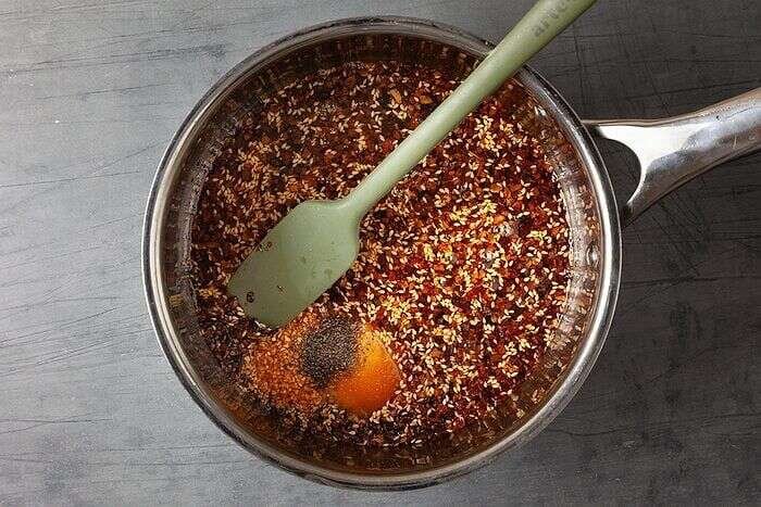 Chili crisp mixture bubbling as it cooks in a saucepan