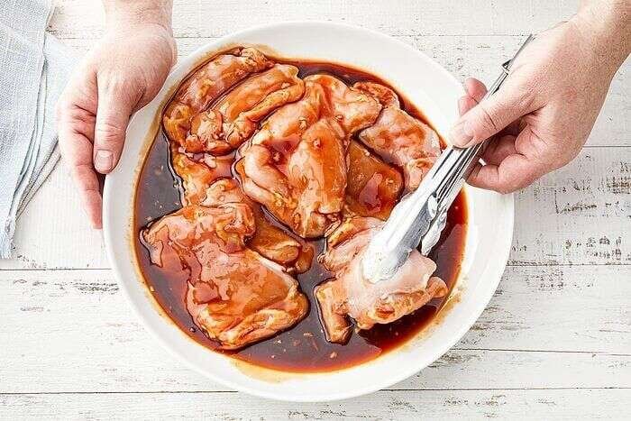 Chicken thighs coated in Huli Huli Chicken marinade before grilling