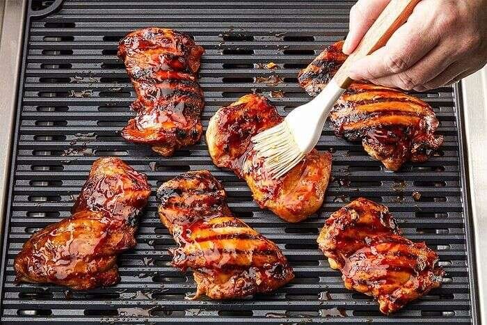 Huli Huli Chicken thighs grilling over medium heat with a caramelized glaze