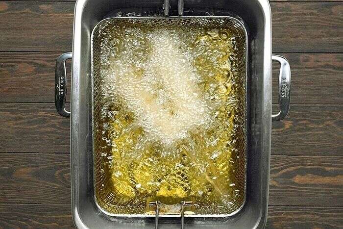 Korean corn dogs frying in hot oil until golden brown