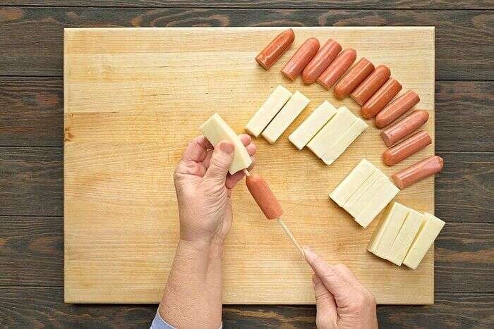 Hot dog and mozzarella threaded onto wooden skewers