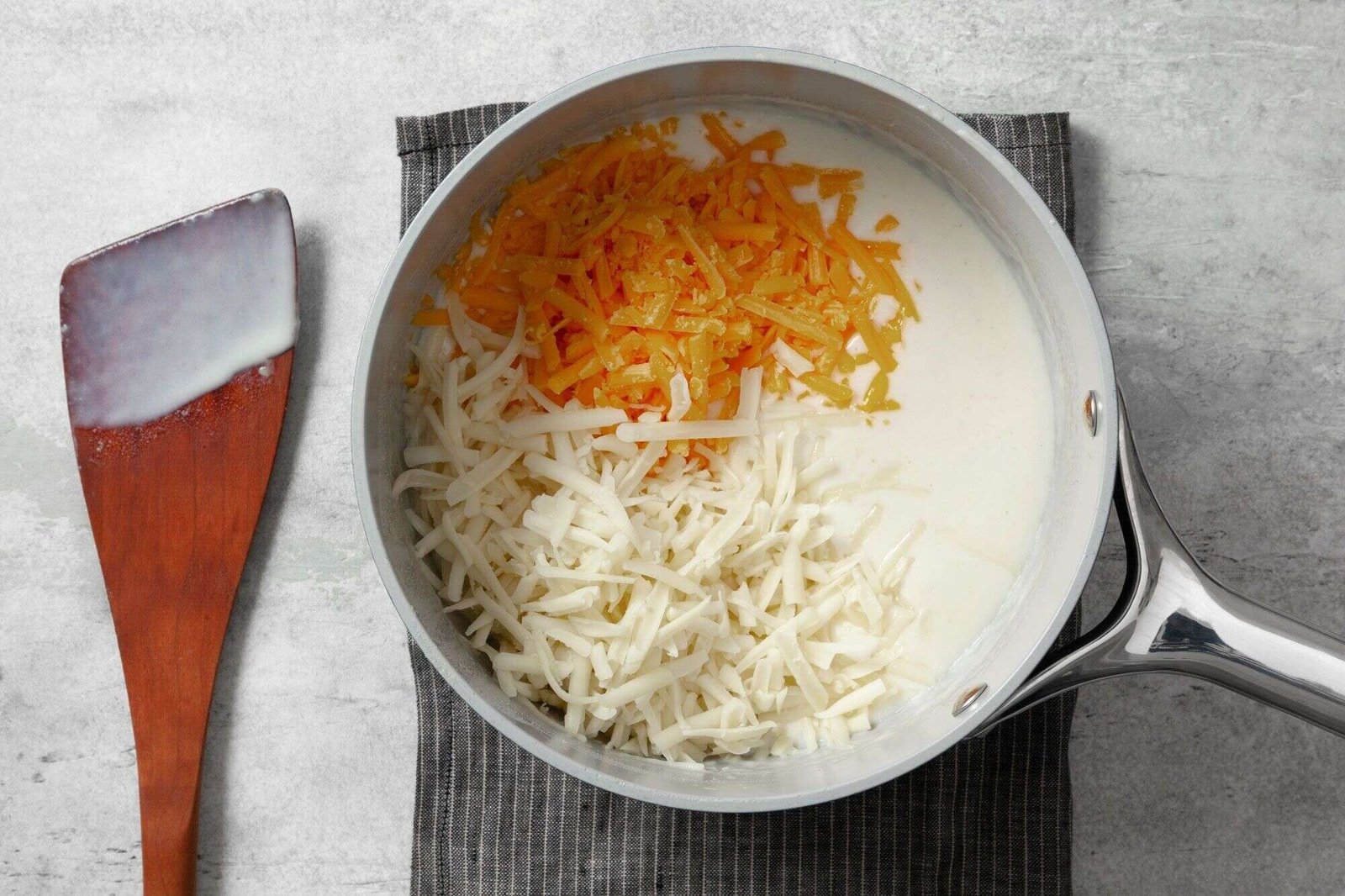 Sharp cheddar and Swiss cheese melting into mac and cheese sauce