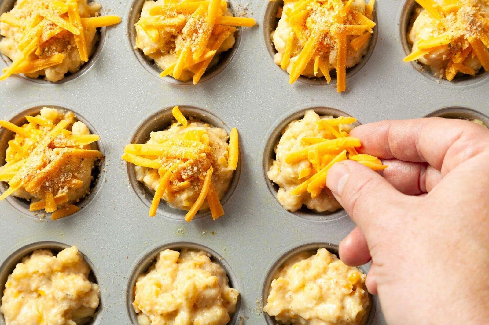 Cheddar cheese and seasoned breadcrumbs sprinkled over mac and cheese bites