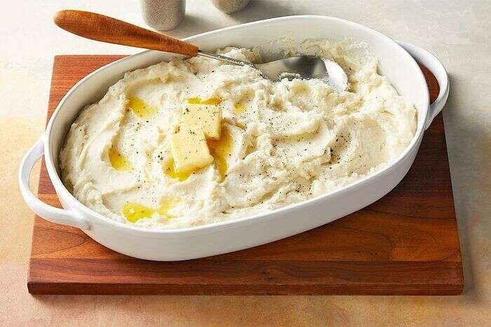 Creamy mashed potatoes reheated with melting butter on top