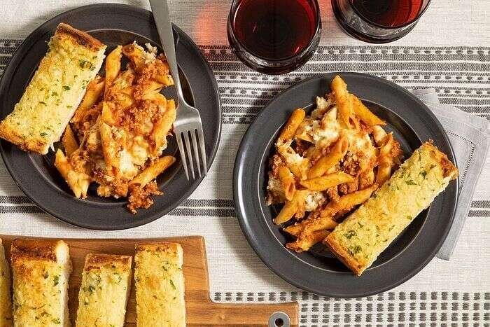 Mostaccioli casserole with pasta and bread served at the table