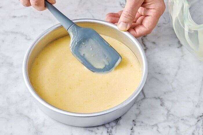 Orange olive oil cake batter spread evenly in prepared pan
