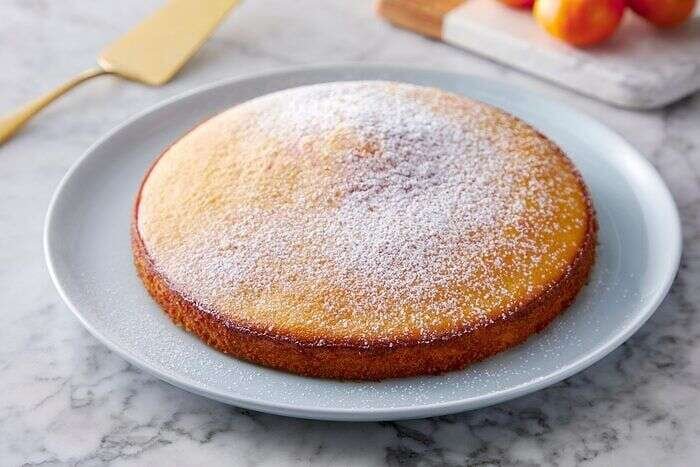 Sugar sprinkled over orange olive oil cake before serving