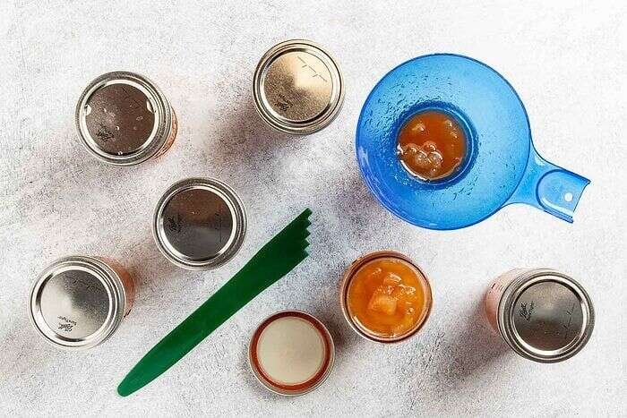 Pear preserves being transferred into canning jars