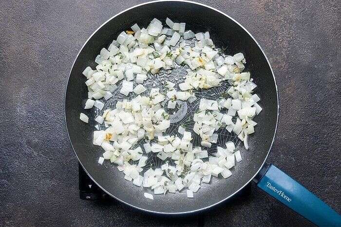 Onion, garlic, thyme, and sage cooking for chicken potpie sauce