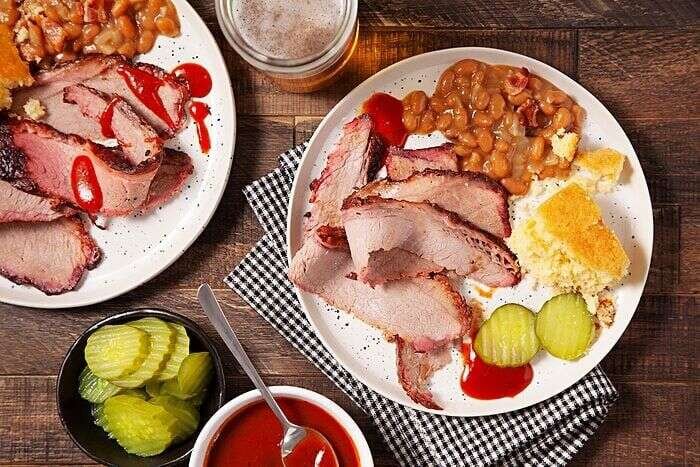 Two plates of sliced smoked brisket ready to serve