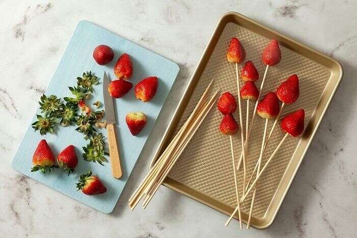 Fresh strawberries threaded onto wooden skewers for tanghulu