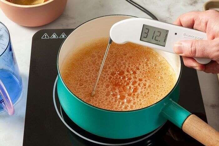 Sugar syrup boiling with a candy thermometer for tanghulu