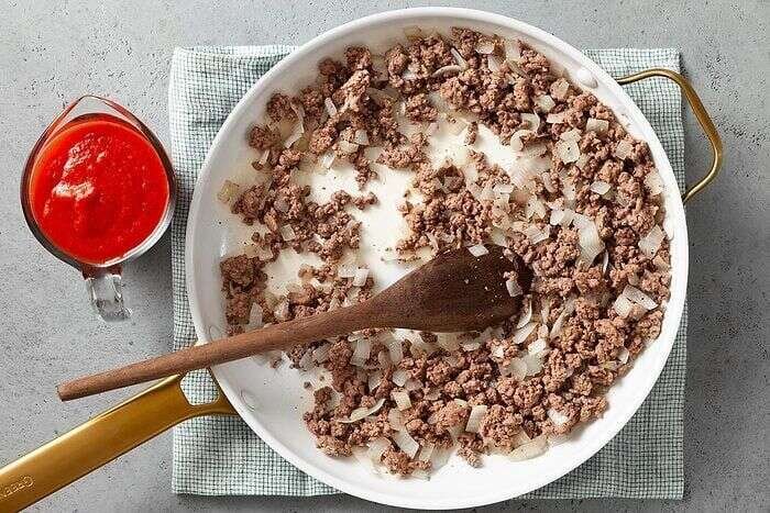 Ground beef and onion cooking for zucchini pizza casserole topping