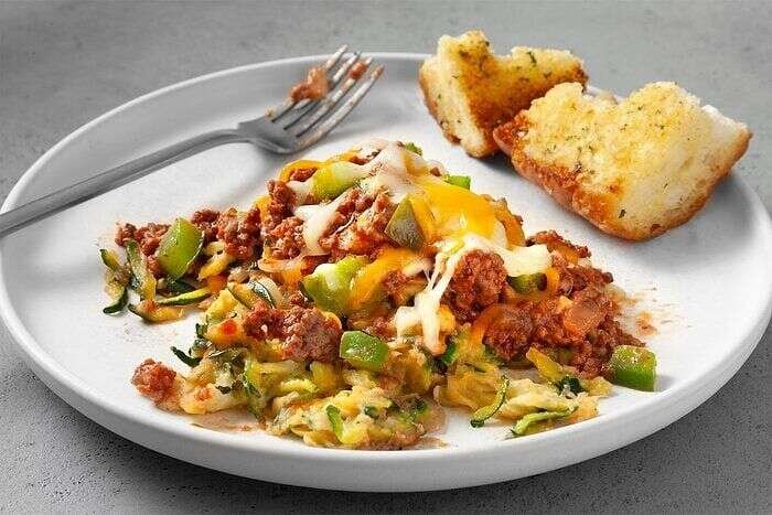 Zucchini pizza casserole served with bread and melted cheese